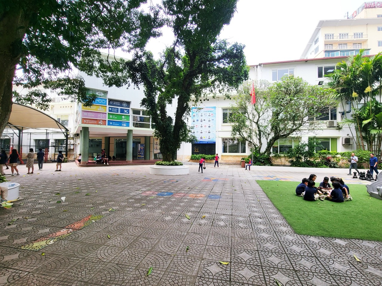 큰 나무가 있는 앞마당과 흰 외벽의 학교 건물